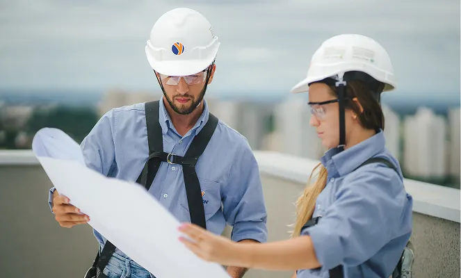 Profissionais da construção civil analisando uma planta