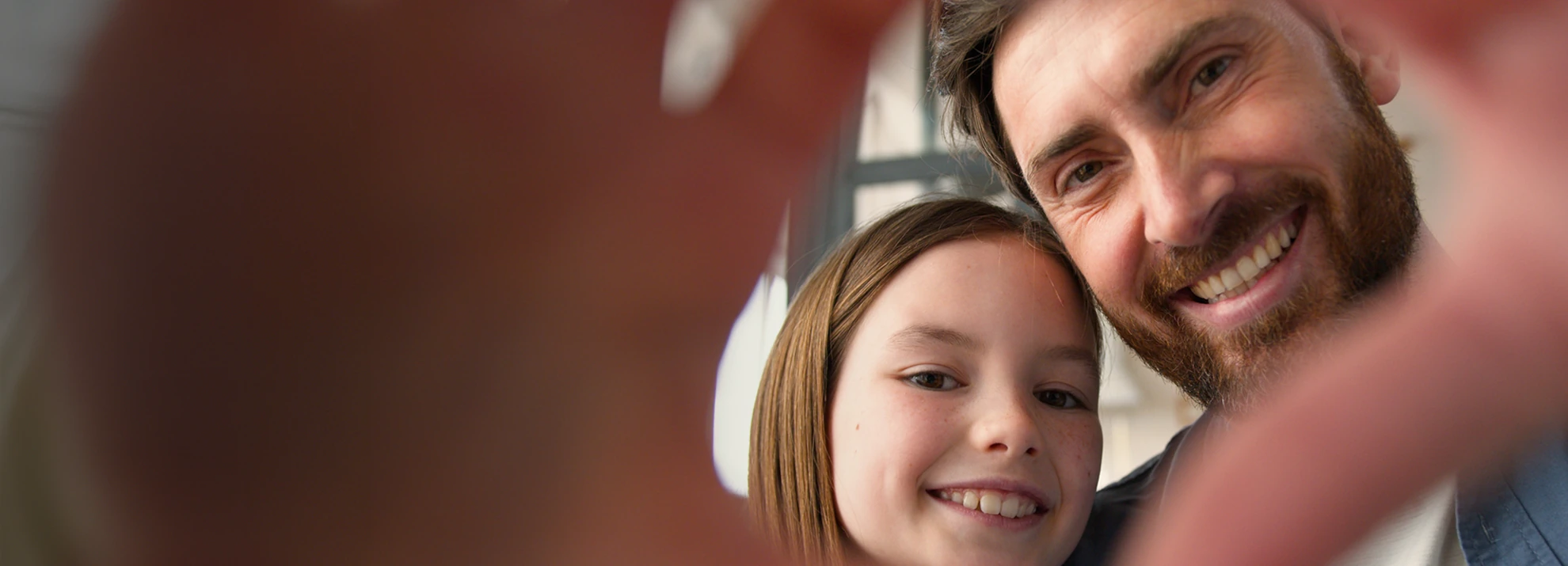 Pai e filha sorrindo para uma foto em seu novo lar